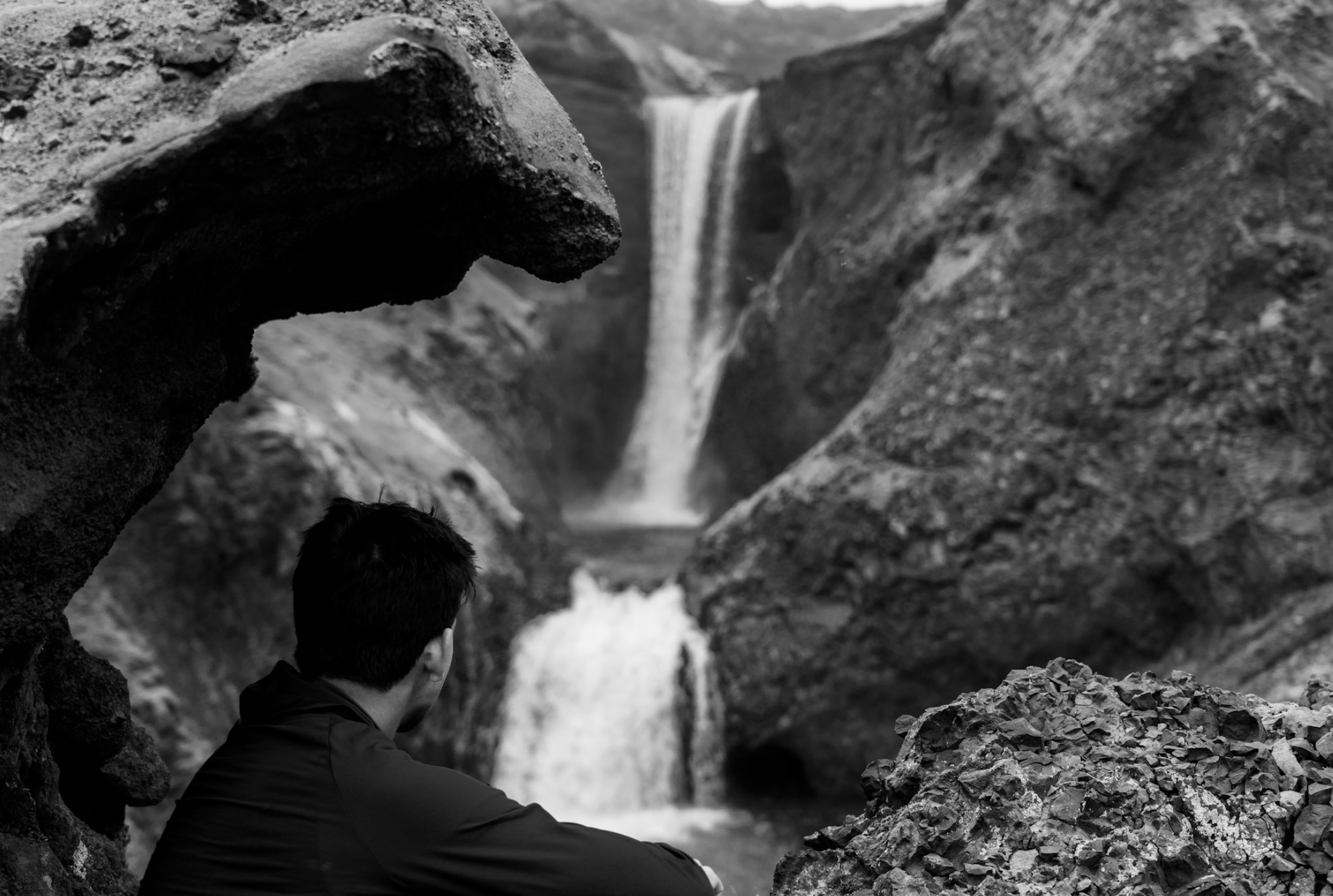 Anand looking toward a waterfall, in black and white